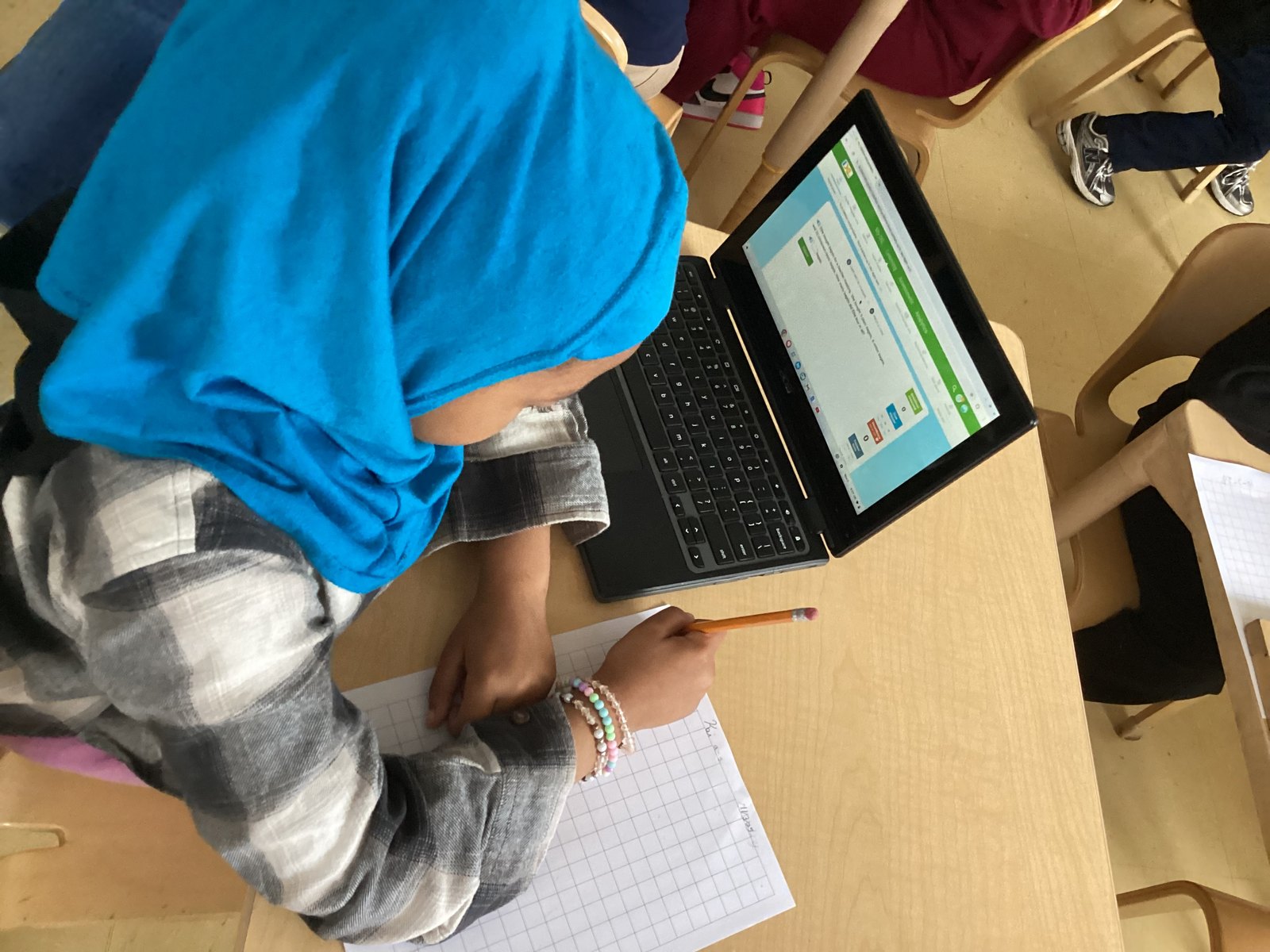 Student using classroom technology while recording learning data